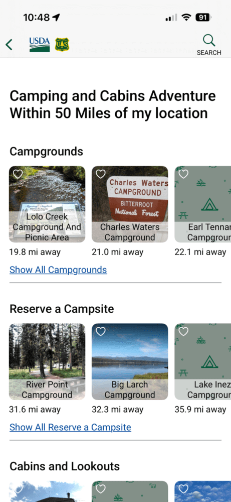 Screenshot of a mobile app listing Forest Service campgrounds within 50 miles, showing Lolo Creek, Charles Waters, River Point, Big Larch, and Lake Inez campgrounds with distances and thumbnail images for each.