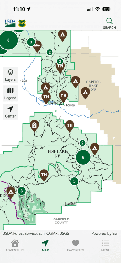 A mobile map showing trails and points of interest in and around Fishlake National Forest, Utah. Green icons mark locations; boundaries of the forest, Capitol Reef National Park, and Garfield County are highlighted with Forest Service detail.