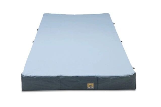 A rectangular gray and light blue inflatable sleeping pad or mattress, viewed from the front, with a small Overland News logo in the center of the lower edge.