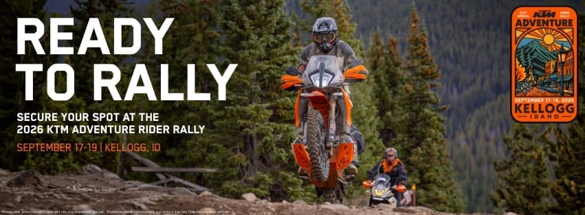 Two motorcyclists ride orange KTM adventure bikes on a rocky forest trail. Large text reads Ready to Rally. Event details for the 2026 KTM Adventure Rider Rally in Kellogg, Idaho are displayed, highlighting its place among top overland events and rallies.