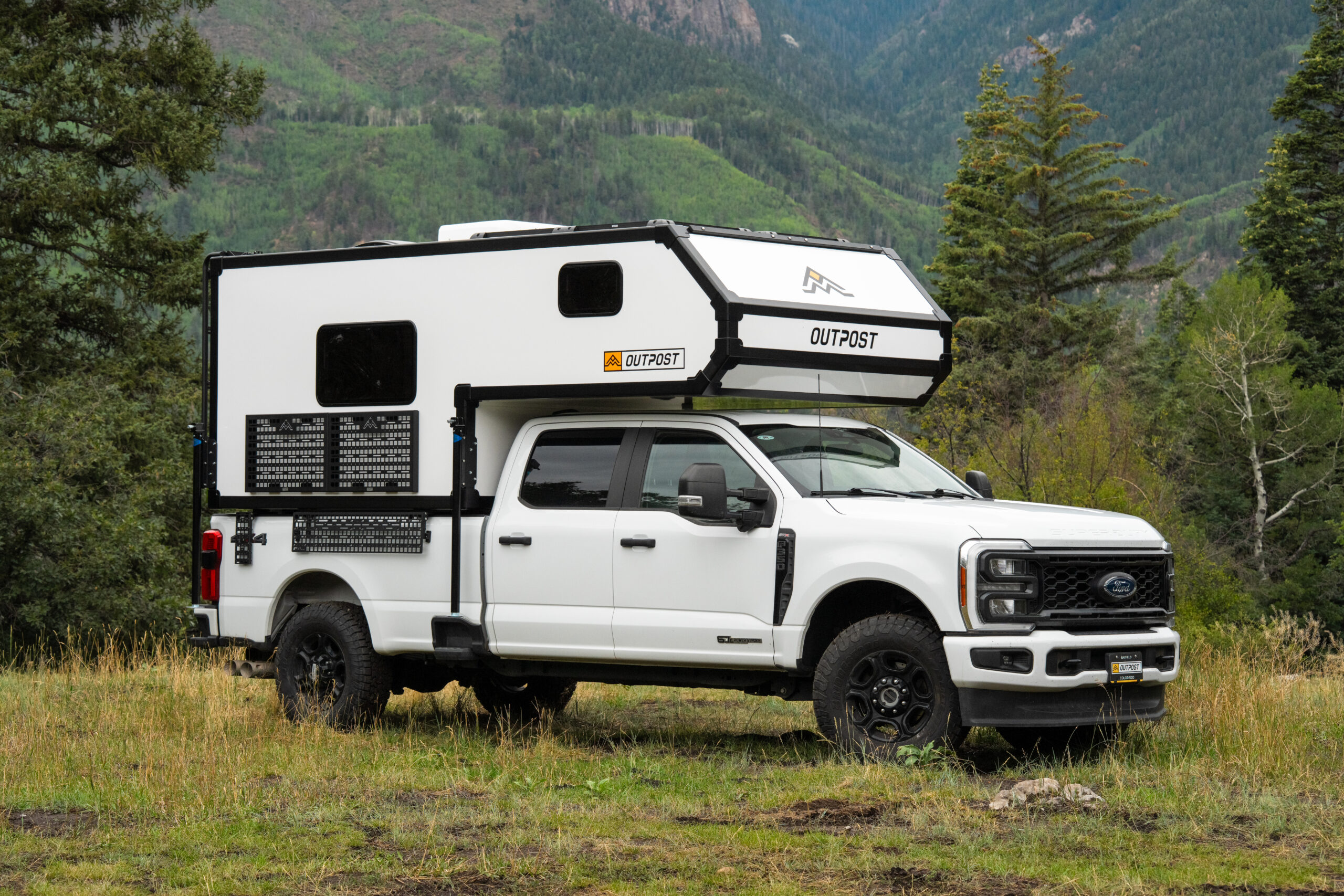 white truck camper parked in grassy area