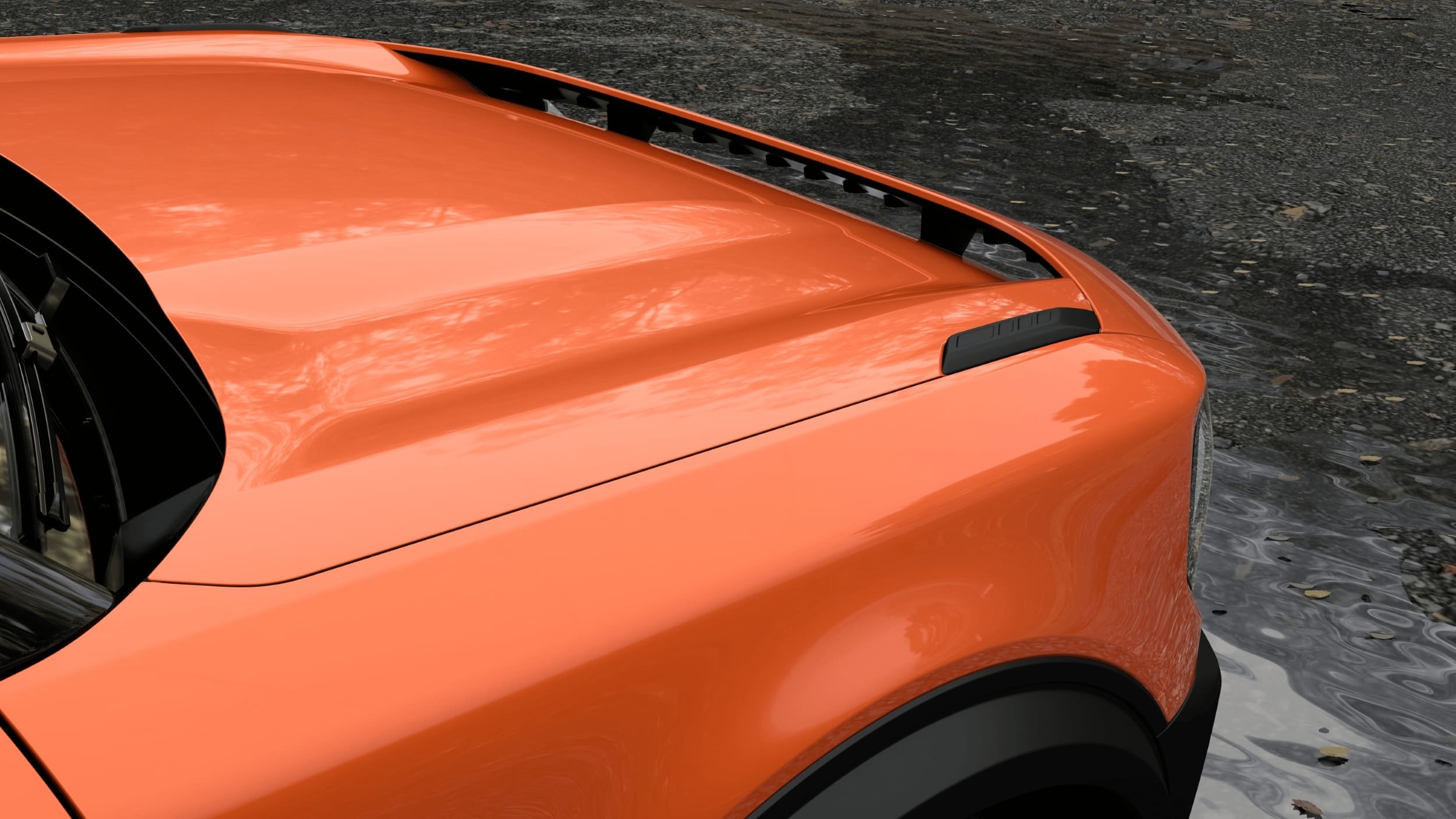 Close-up of the front left hood and fender of an orange Ford Bronco parked on wet, textured pavement, with reflections of trees visible on the car’s surface.