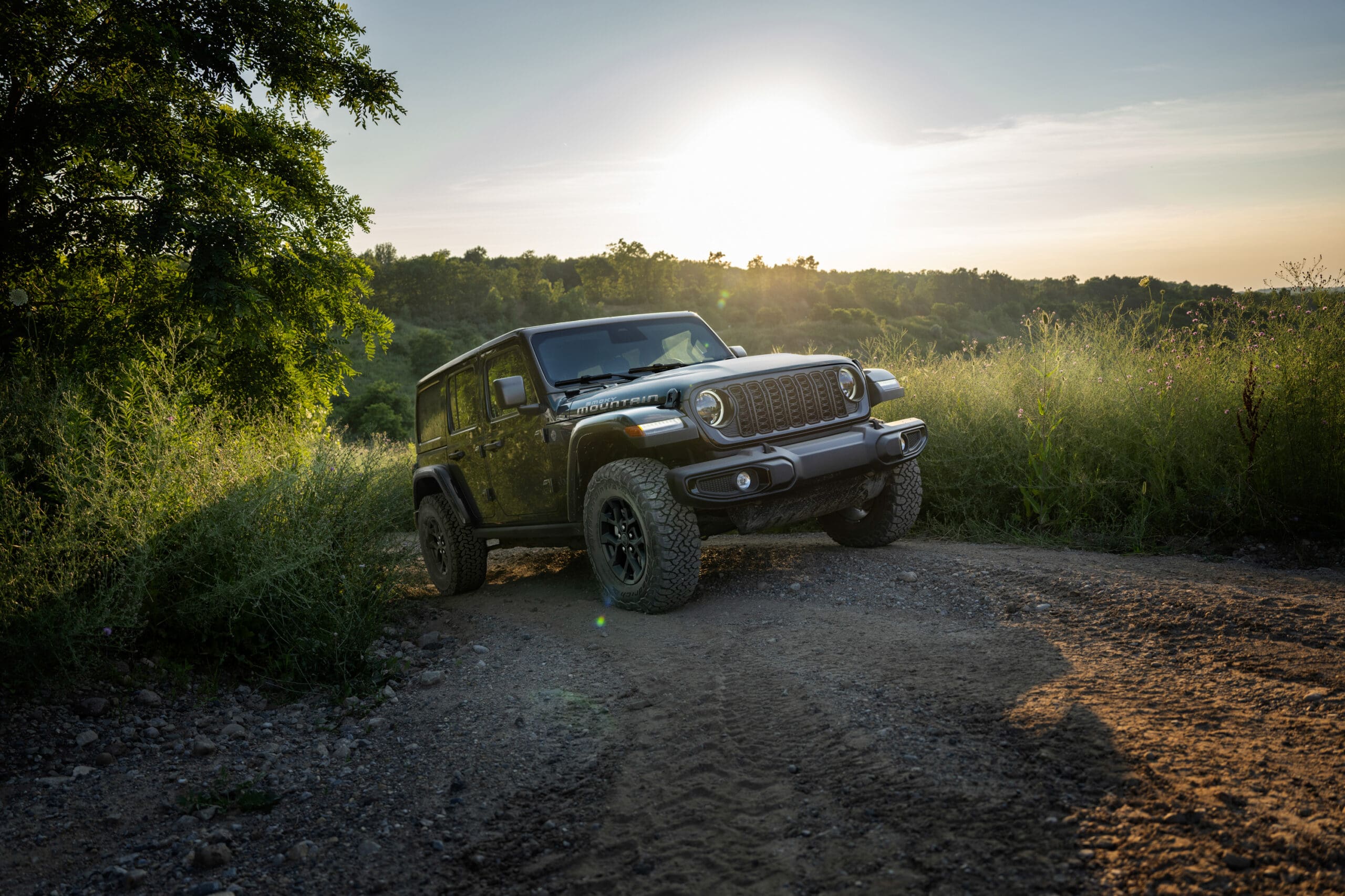 jeep driving off-road at sunset
