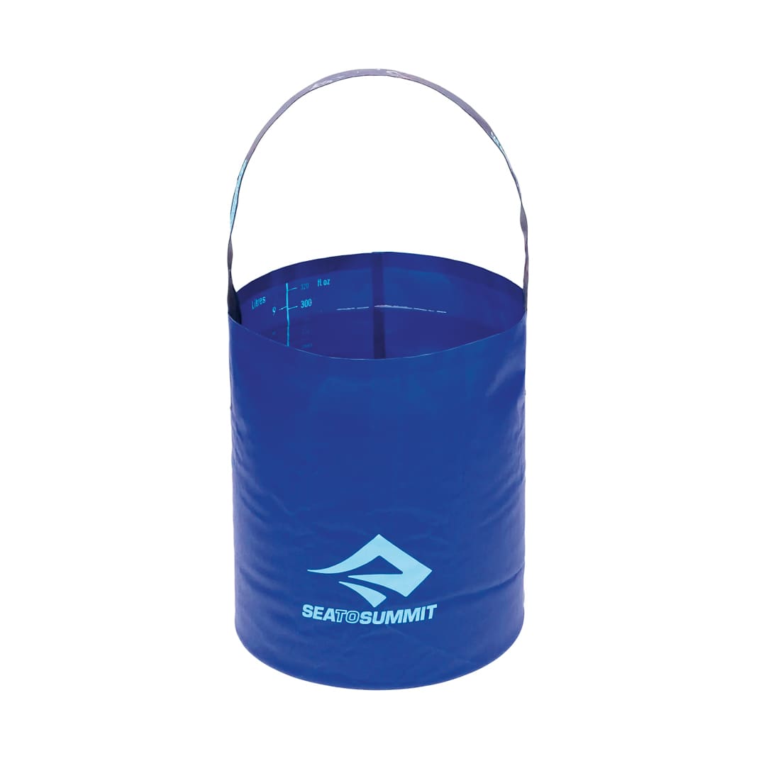 A blue collapsible bucket with a handle and Sea to Summit logo on the front. Perfect for laundry at camp, the bucket is open and upright, showing capacity markings inside.