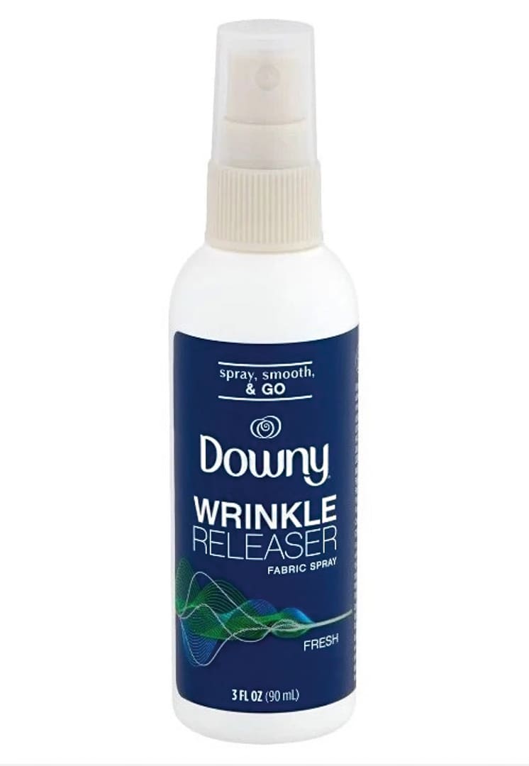 A white spray bottle of Downy Wrinkle Releaser fabric spray with a dark blue label, green and blue wave design, and text indicating it is fresh scent, 3 fl oz (90 ml)—a handy Gear Callout for tackling laundry at camp or on the go.