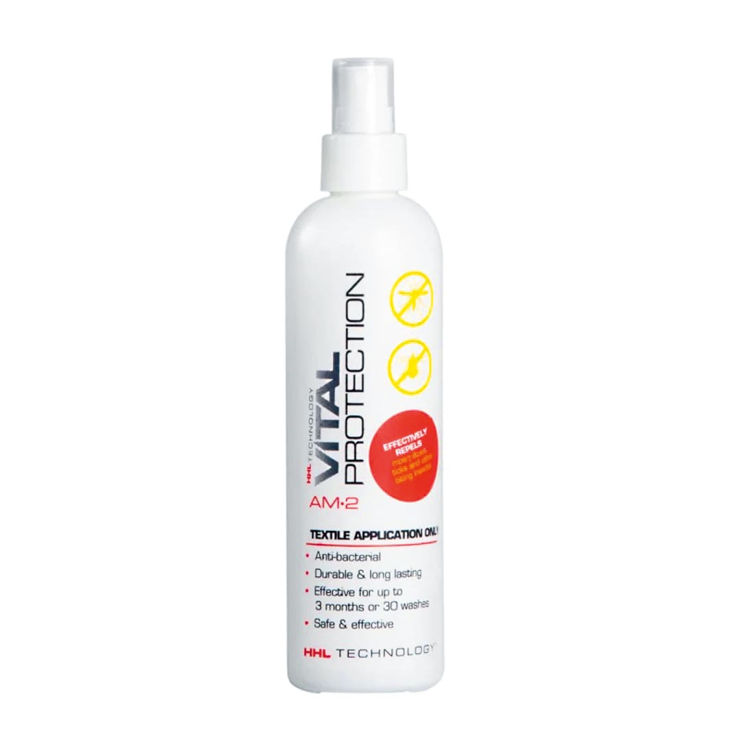A white spray bottle labeled Vital Protection AM2 for textile application, ideal for laundry gear or refreshing camp laundry. The label highlights its antibacterial, long-lasting, and effective properties, with red and yellow graphics and a white spray nozzle.