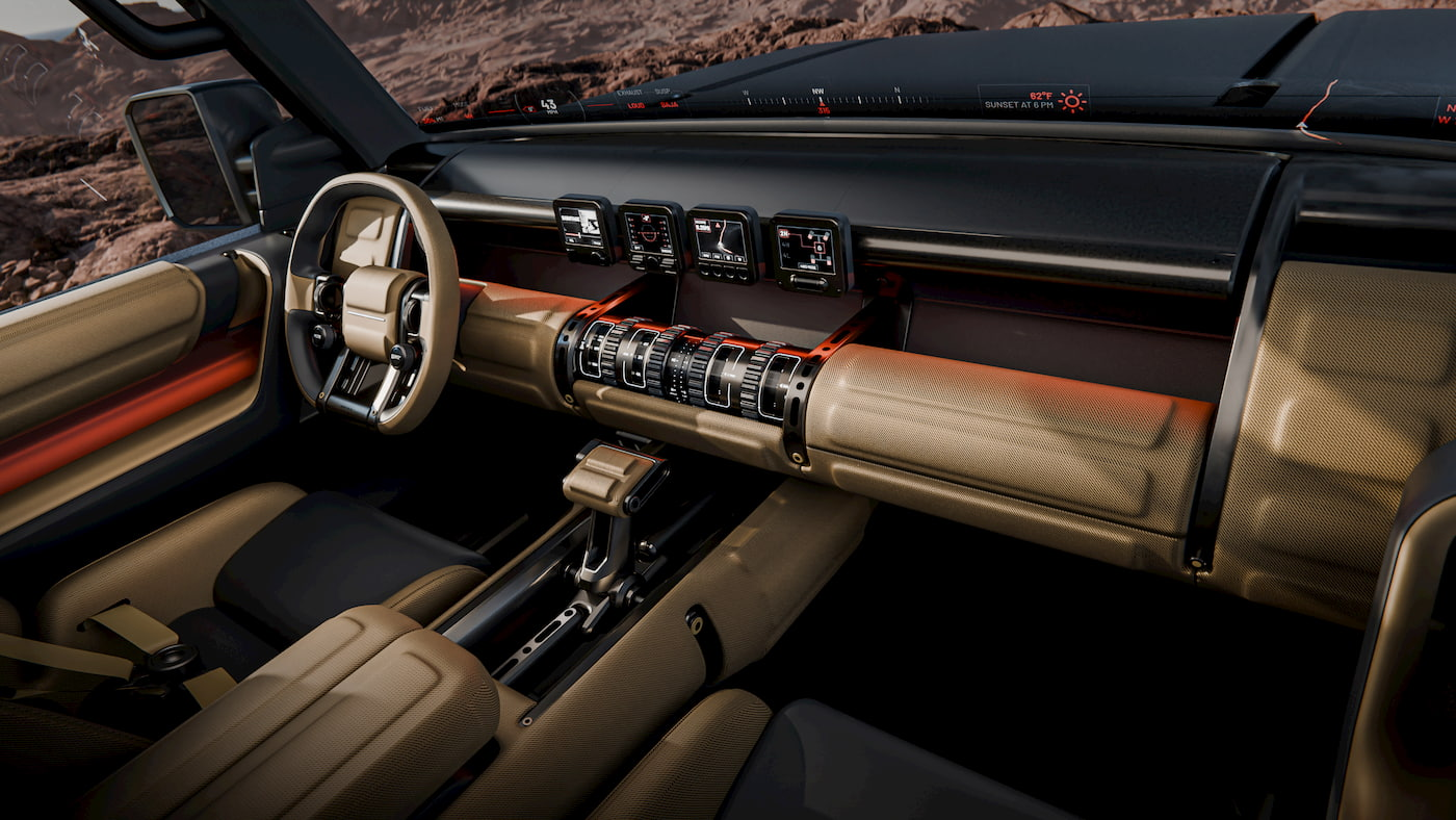 The interior of the modern Hyundai off-road vehicle features tan seats, a rugged dashboard with four digital displays, round air vents, and a sturdy steering wheel, set against a rocky outdoor background.