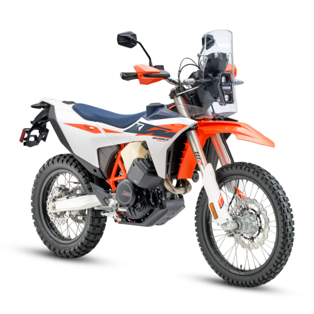 A 2027 KTM 690 Rally adventure motorcycle with knobby tires, orange, white, and blue bodywork, and a clear windshield, shown on a plain white background.