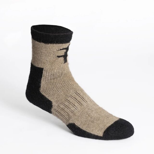 A single wool sock with black heel, toe, and cuff, and tan body, displayed on a white background—perfect for those who love to stay updated with Overland News while enjoying comfort and warmth.