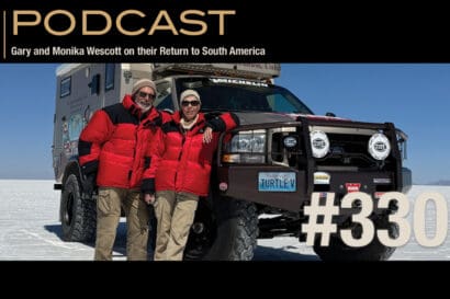 Gary and Monika Wescott stand in front of their expedition truck on a salt flat for podcast episode 330.