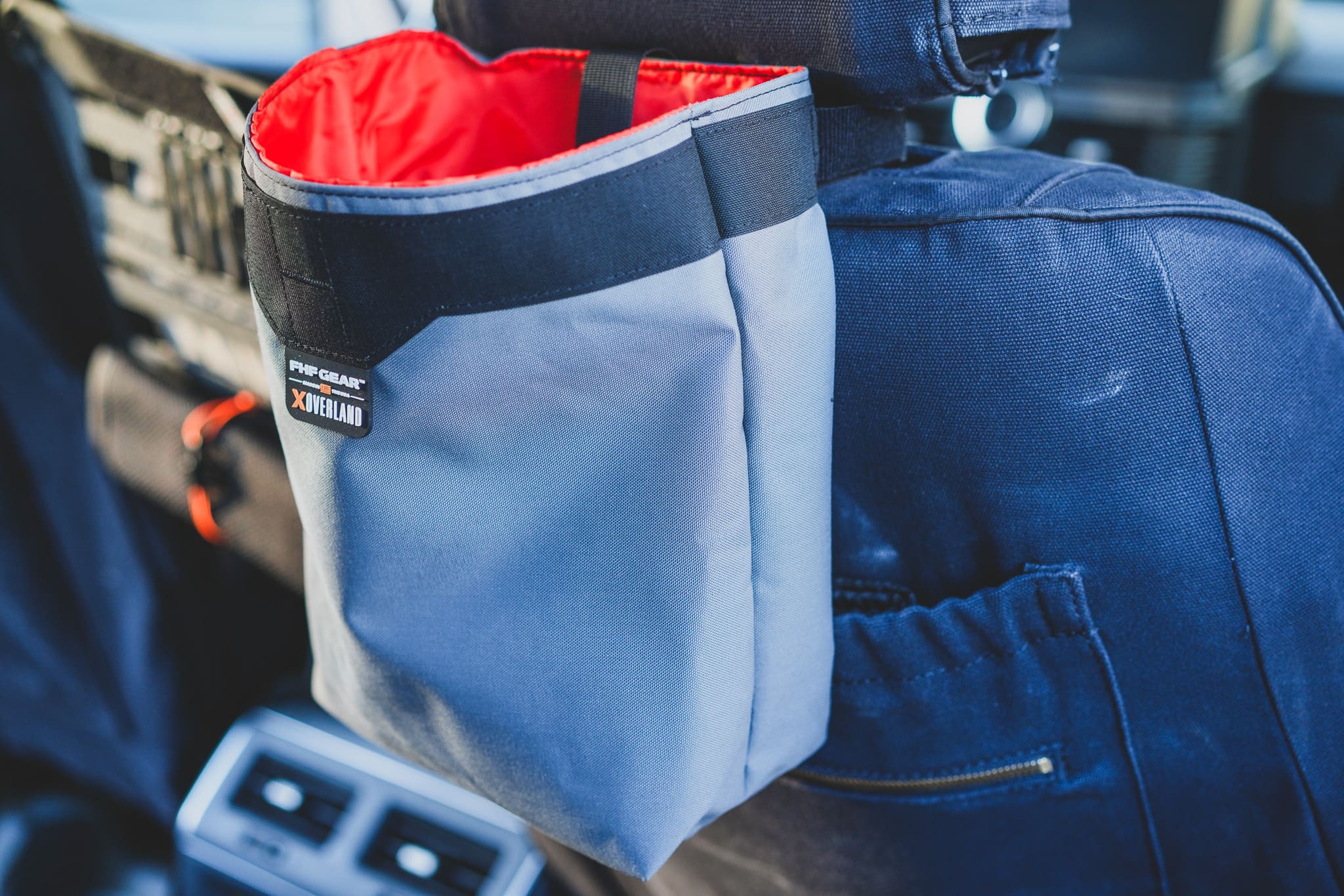 Grey FHF Gear car seat-back trash bag with a red interior and an XOVERLAND logo patch.