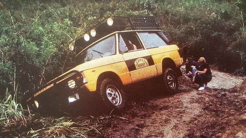 Yellow Range Rover SUV tipping over in the mud